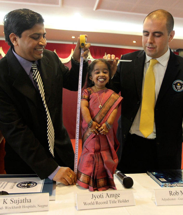 Image: The Guinness World Records adjudicator Rob Molloy and Indian doctor K. Sujatha measure the height of Jyoti Amge, the world's shortest living woman, on her 18th birthday in the central Indian city of Nagpur